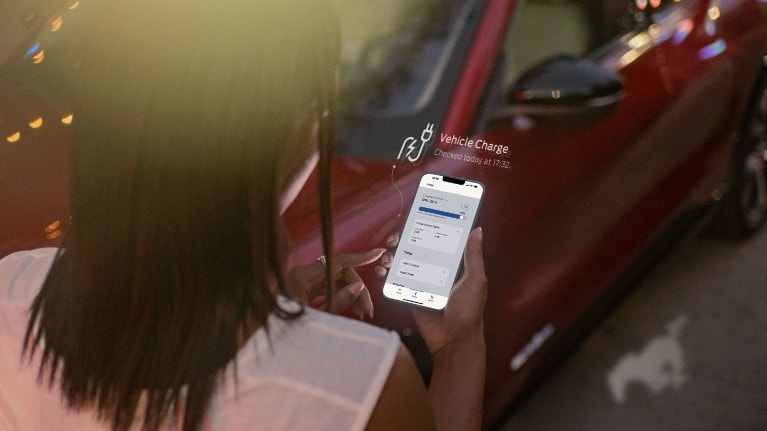 Femme utilisant l'application Ford pour la recharge de son véhicule
