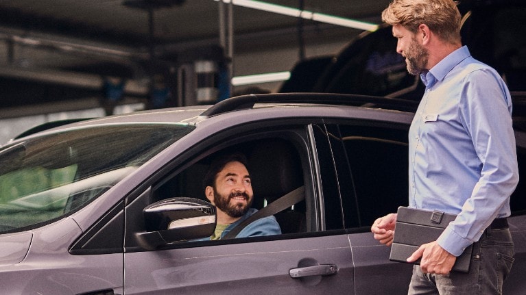 Client souriant dans Ford grise