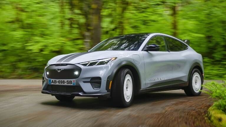 Ford Mach-E grise roulant dans la forêt