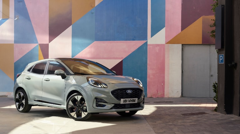 Ford Puma garée devant un mural coloré