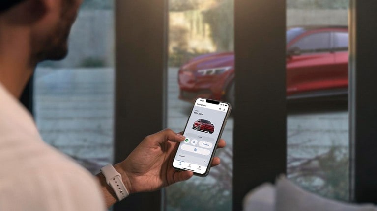 Homme utilisant l'application Ford pour vérifier les paramètres du la fonction démarage à distance