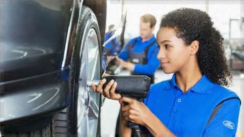 Technicienne Ford serrant les boulons d'une roue