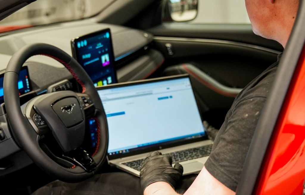 Mekaniker med laptop i bil