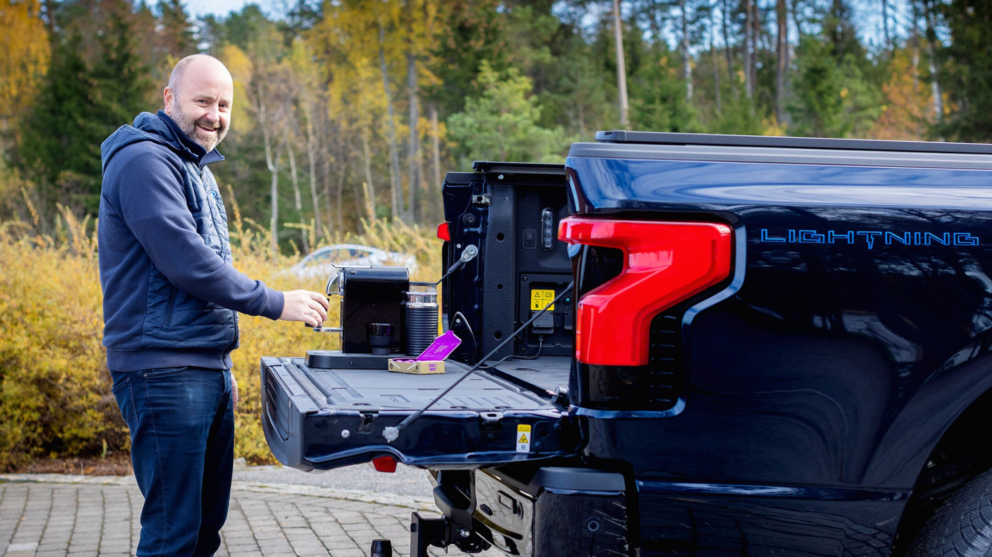 Mann lager kaffe ved Ford F-150 Lightning