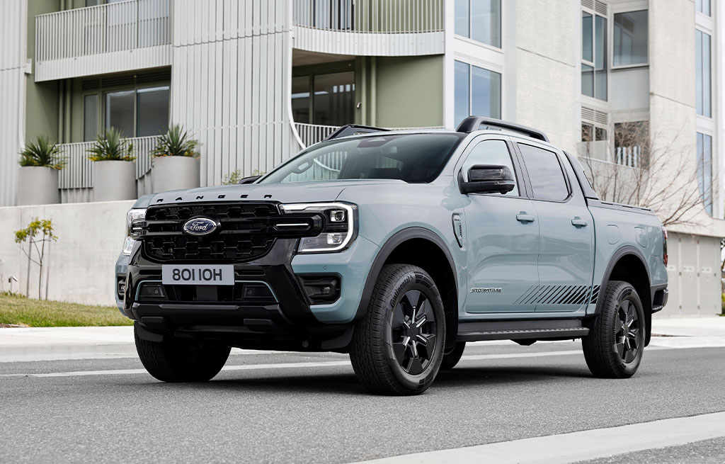 Ford Ranger Plug-in Hybrid pickup parked outside modern apartment building in the city