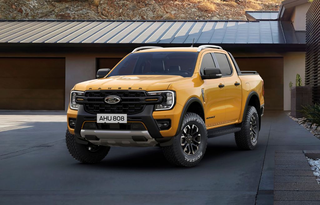 Gul Ford Ranger pickup parkert foran hus med offroad-dekk