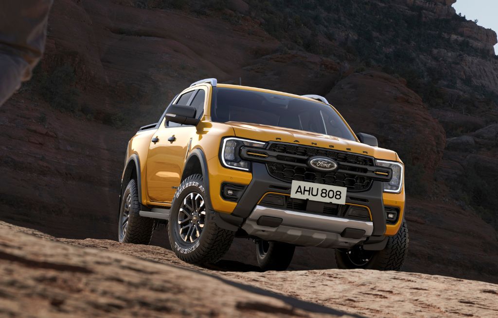 Gul Ford Ranger pickup på steinete terreng med robuste offroad-dekk