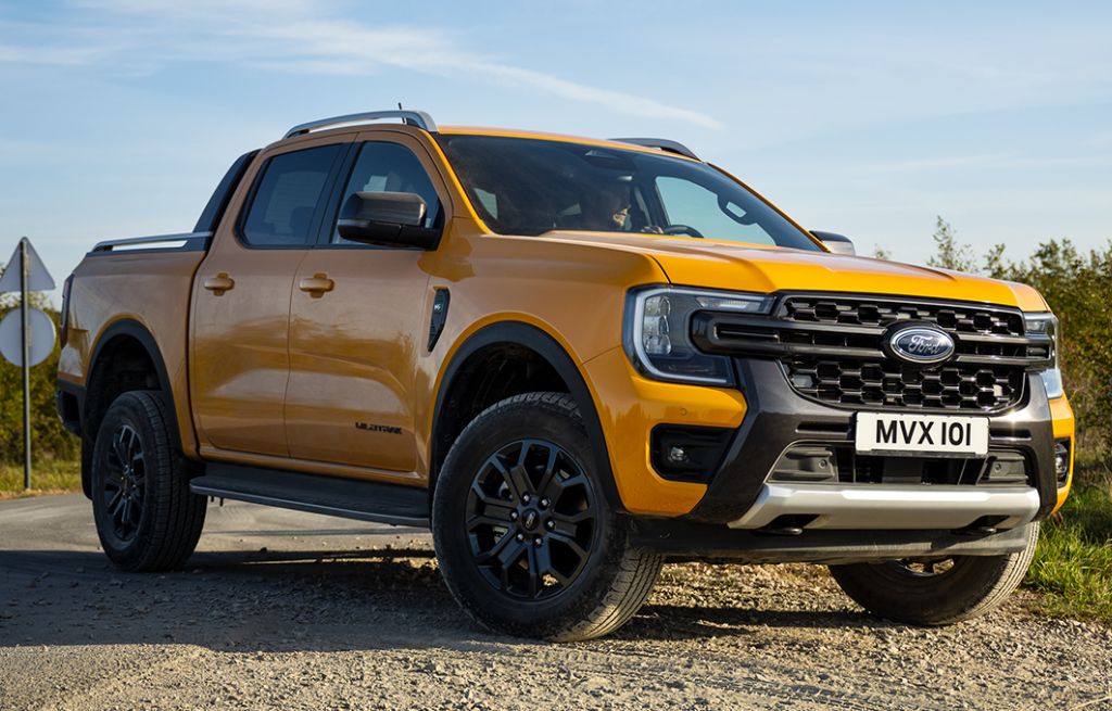 Yellow Ford Ranger parked on a country road under clear sky