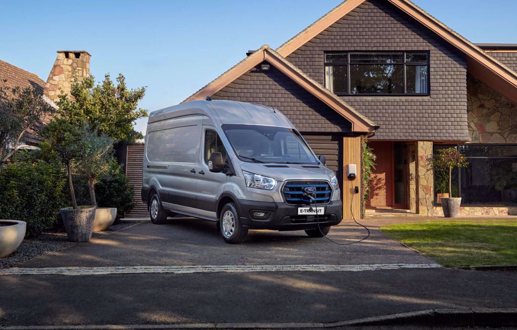 Silver Ford E-Transit parkerad utanför en byggnad