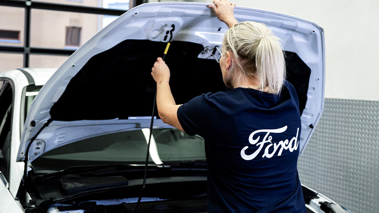 Ford-tekniker utför service och kontroll under motorhuven på en Ford-bil.