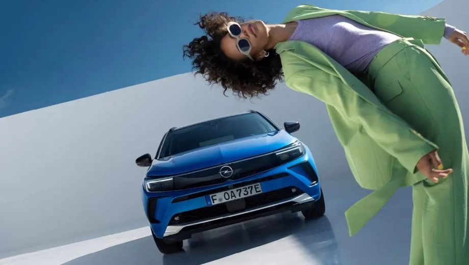 Blå SUV bakom poserande person